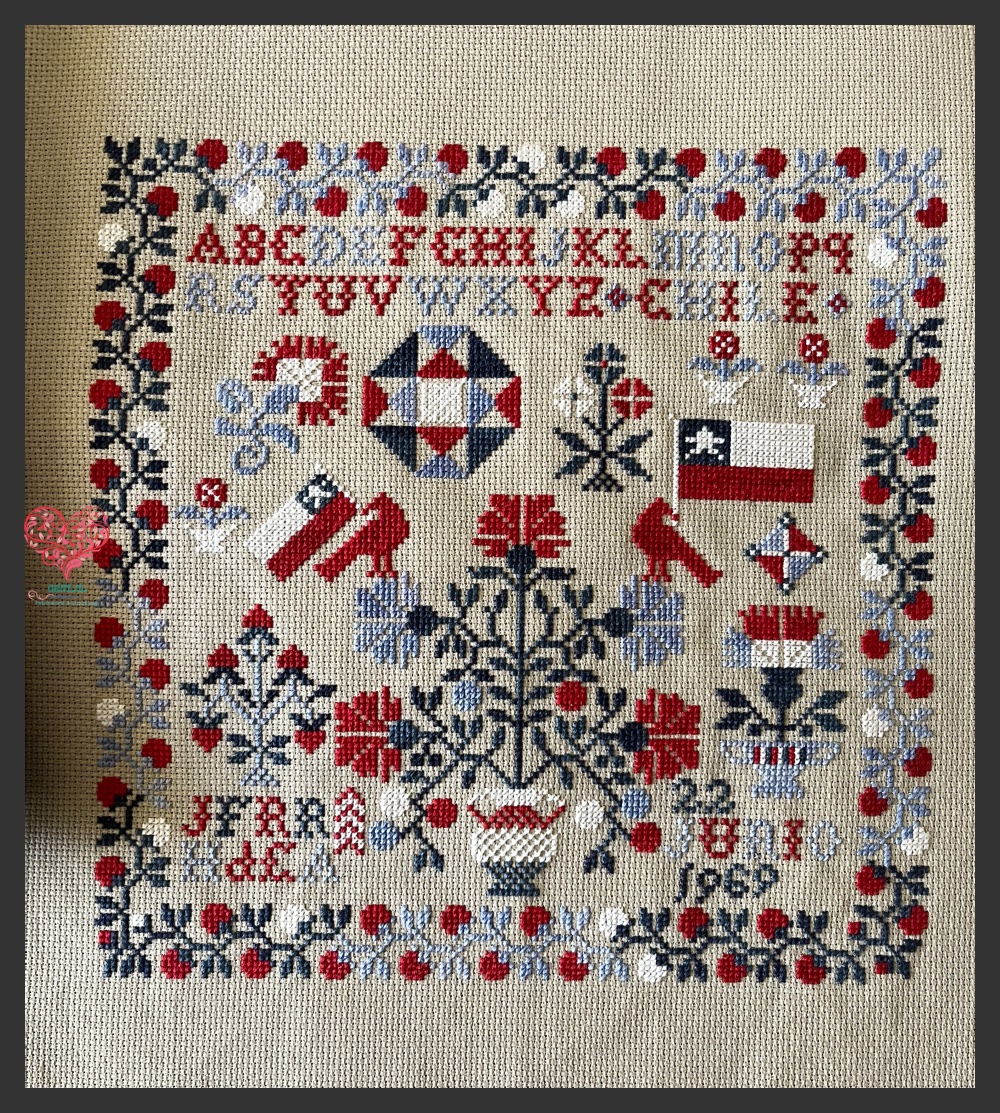 Salute to Abigail de Blackbird Designs adaptado como sampler patriótico en punto cruz en honor al abuelo de la autora, bordado en colores rojo, blanco y azul con motivos florales, estrellas y símbolos patrióticos.