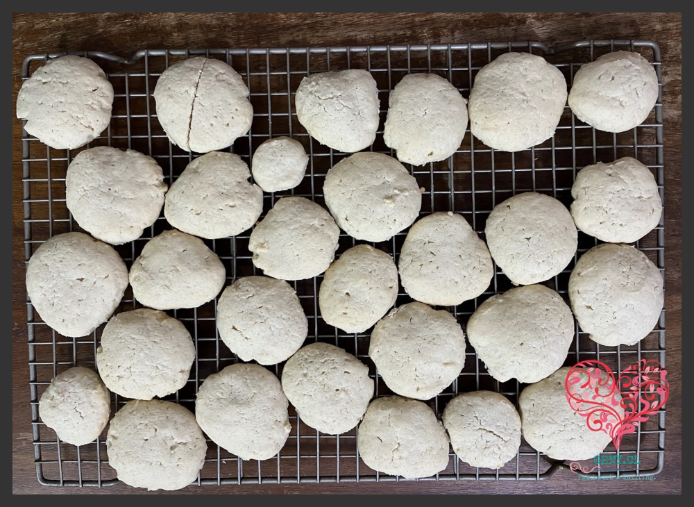 Galletas de queso caseras enfriándose sobre una rejilla metálica después del horneado.