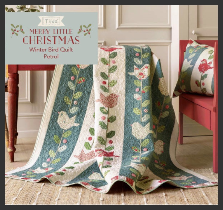 Winter Bird Quilt en tonos azul y blanco con cojín a juego.