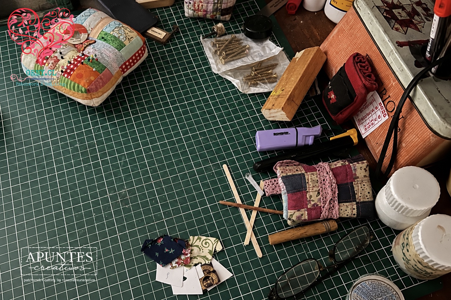 escritorio de madera con mat de corte y cosas de costura y maquetería.