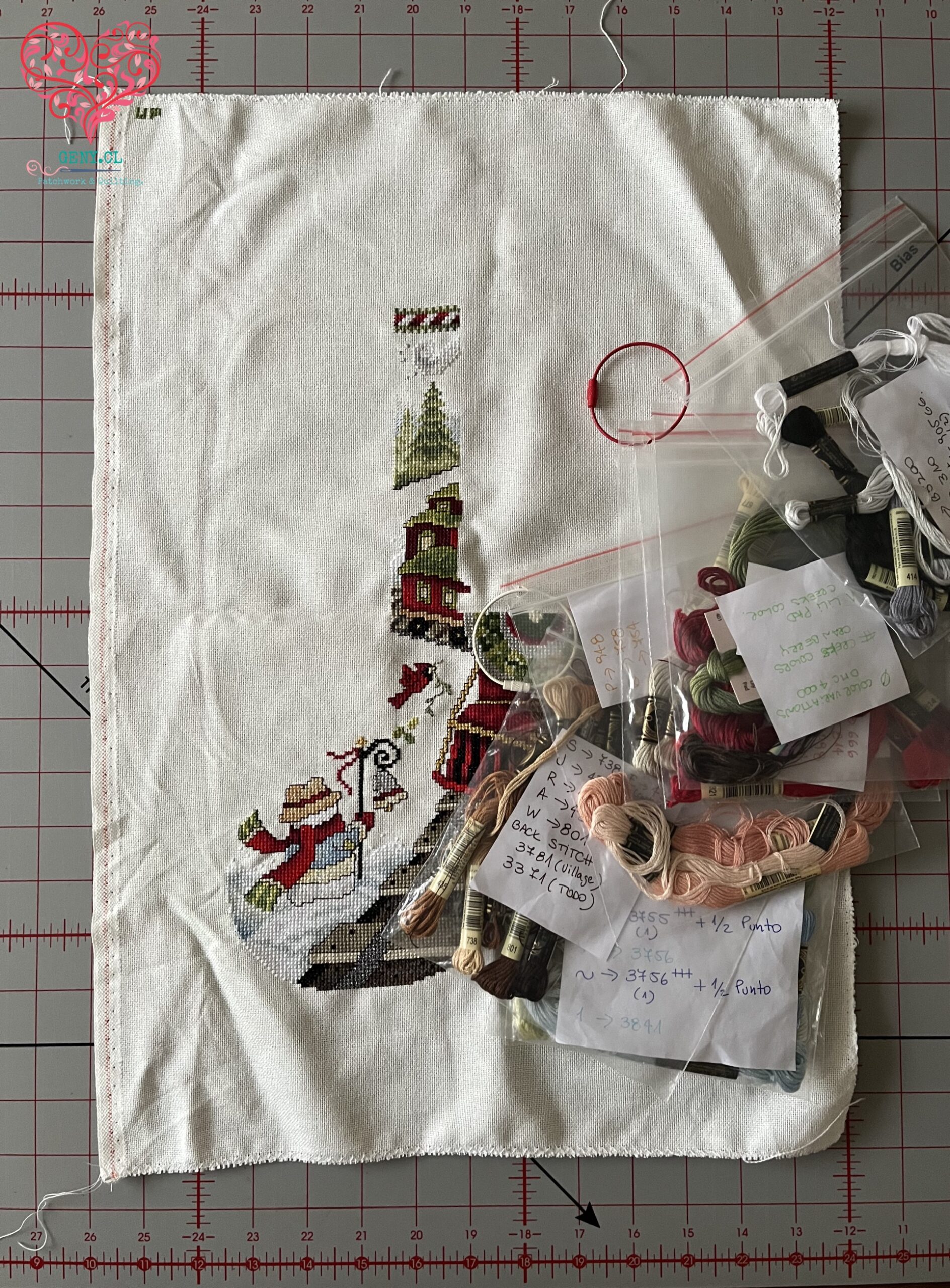Avance de una bota de Navidad bordada en punto cruz con los hilos del proyecto sobre la tela para mantener en secreto el diseño central antes de Navidad.