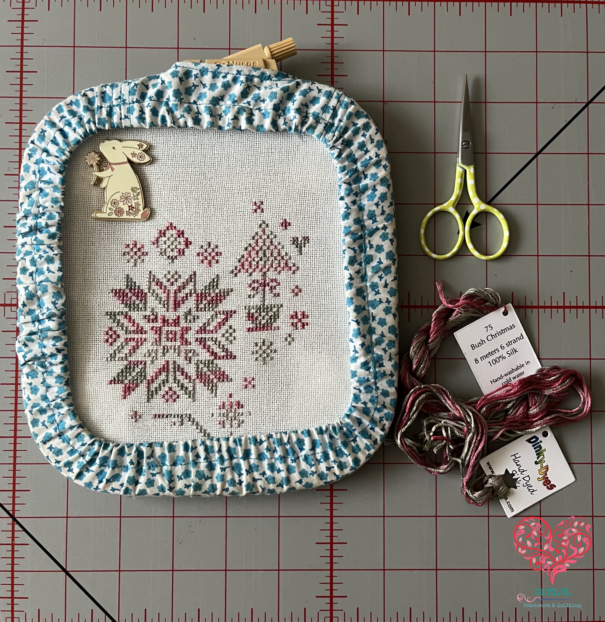 Avance diario del bordado Christmas Quaker en punto cruz, acompañado de hilos y accesorios de bordado como parte de mi rotación de bordados de invierno.