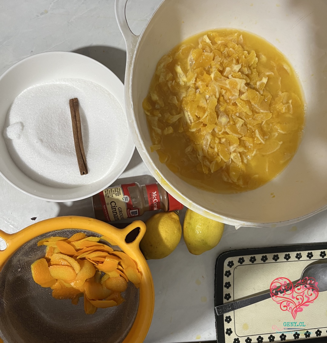 Naranjas, azúcar y canela preparados para cocinar mermelada de naranja casera.
