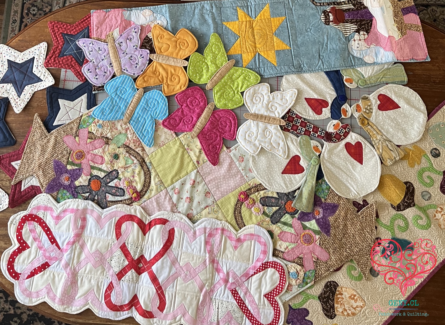 Colección de centros de mesa de patchwork para distintas celebraciones y estaciones, reunidos sobre una mesa de madera.