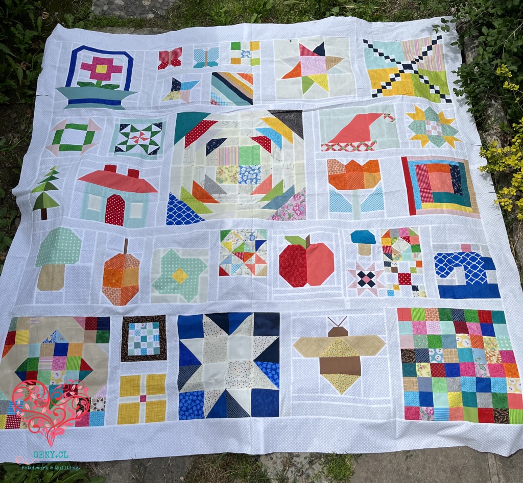 Top de quilt scrappy con numerosos bloques de patchwork en diferentes colores y estampados.
