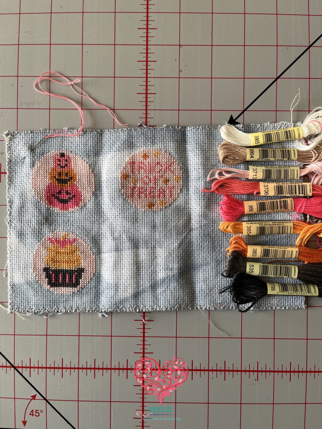 Dos bordados de punto de cruz de la colección Spooky Cute Ornaments de Fat Quarter Shop: Trick or Treat y un cupcake decorado con un murciélago.