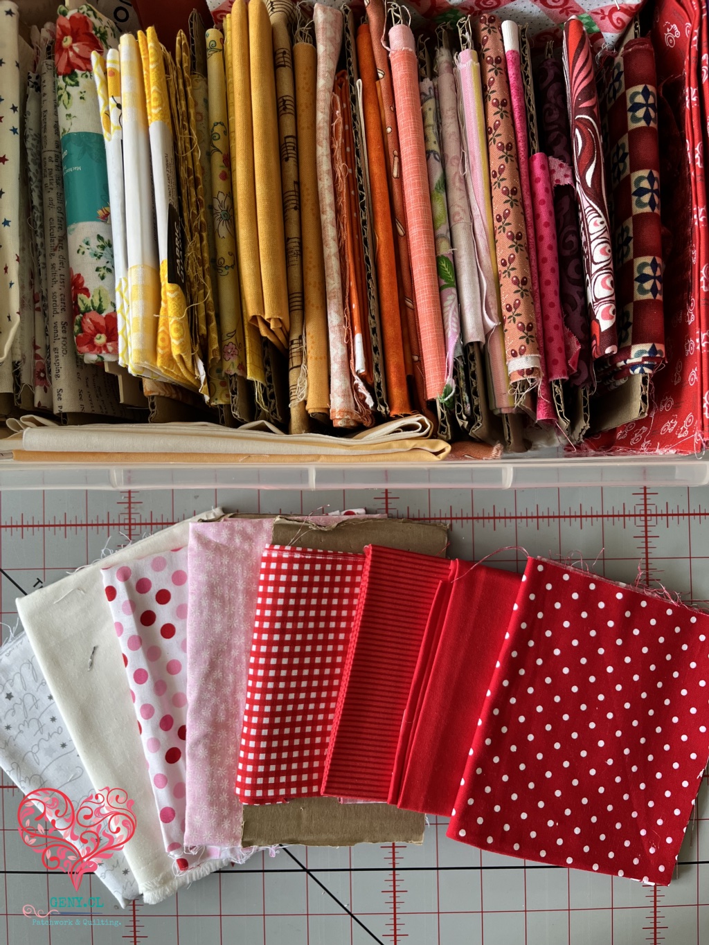 Telas de patchwork organizadas por color, desde blancos y rosados hasta rojos.